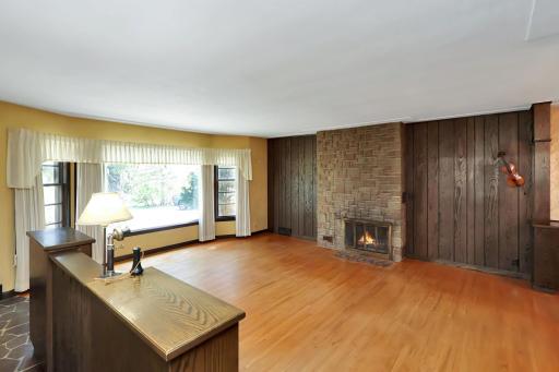 Front living room with wood fireplace and real wood floors.