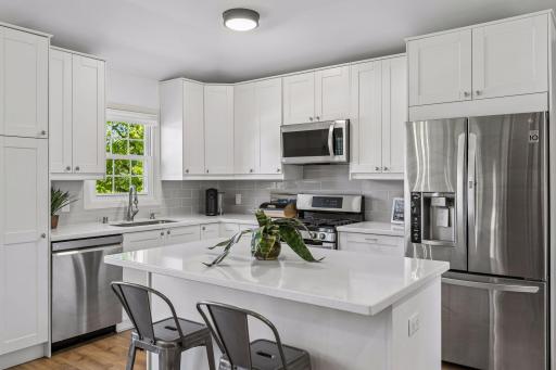 The beautifully renovated kitchen is light and bright with stainless appliances, a handy breakfast bar, stylish subway tile and a window overlooking the fully fenced back yard.