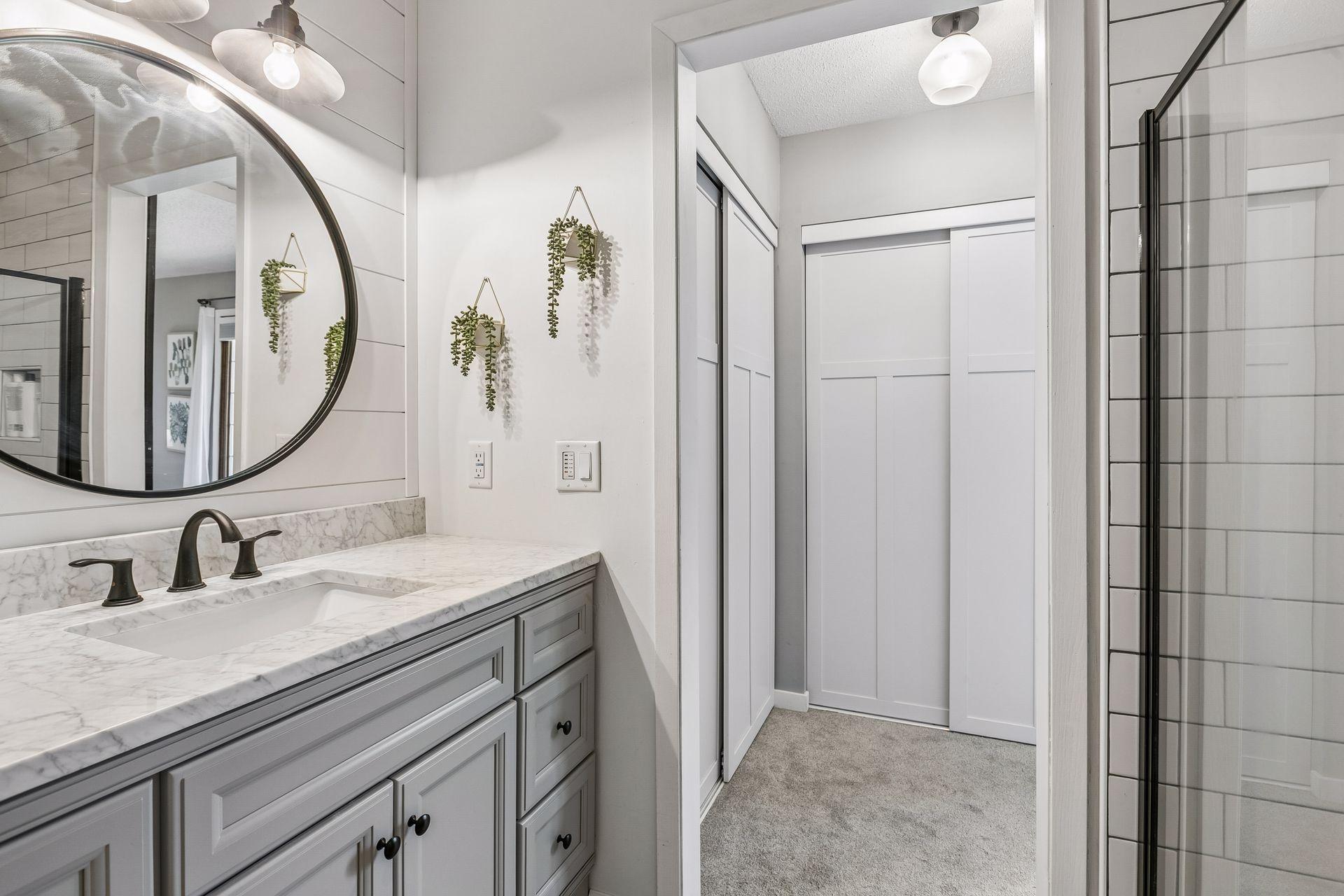 Stylish details of the owners bath include ship-lap details, oil rubbed bronze fixtures and glassed shower doors.