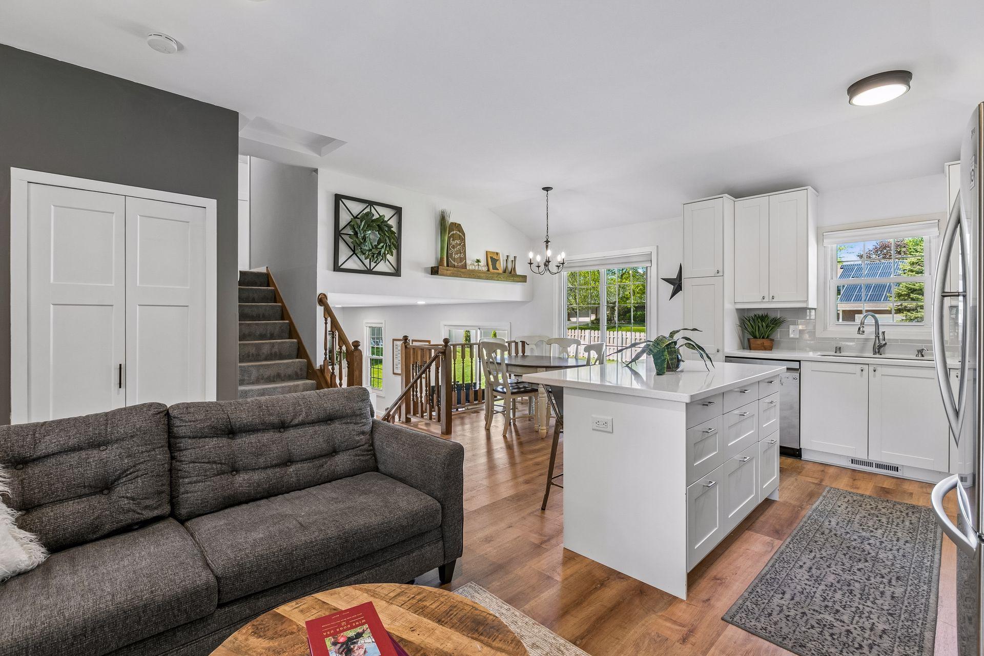 The living area is open to the kitchen with solid surface flooring and a tray ceiling to unify the spaces.