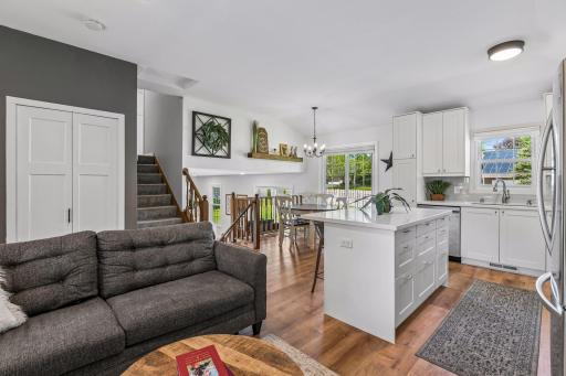 The living area is open to the kitchen with solid surface flooring and a tray ceiling to unify the spaces.