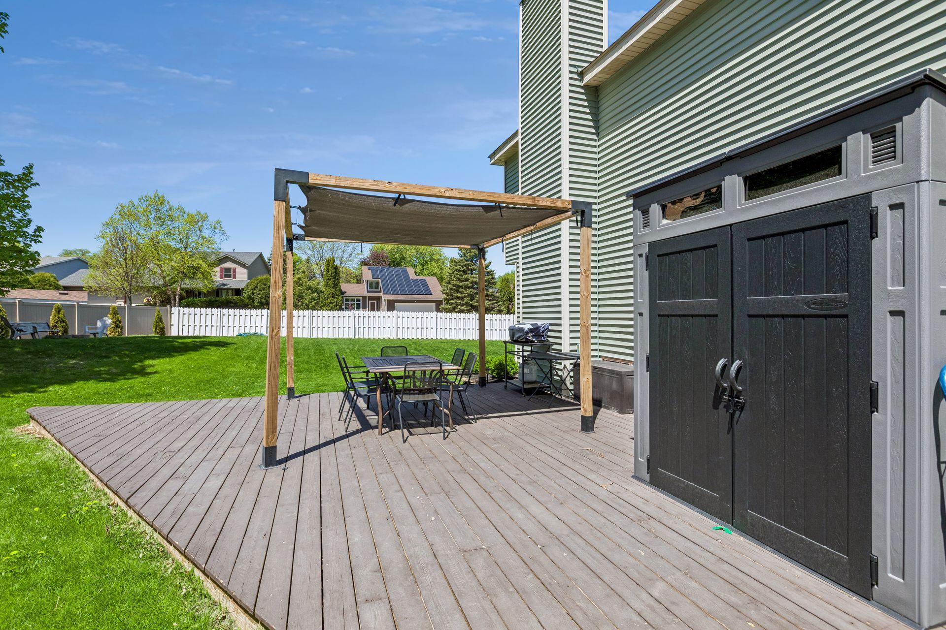 The side deck is spacious and bright with a pergola for shade and a storage shed for your garden tools and deck extras.