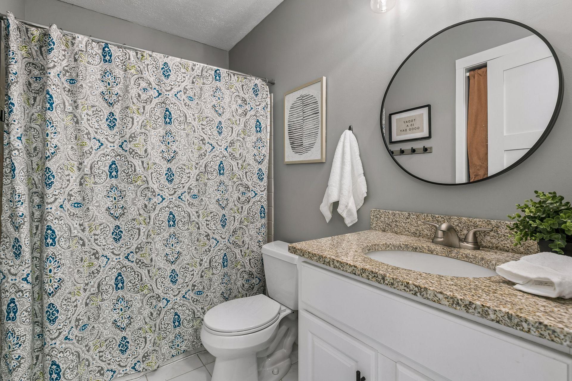 The upper level full bath has an updated storage vanity with stone countertop and updated fixtures.