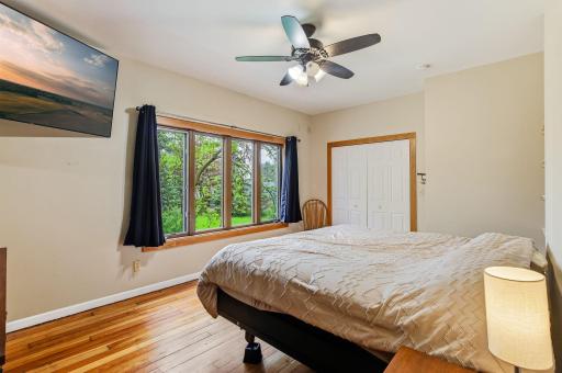 Upper-level primary bedroom with soft natural light and a warm, restful feel.