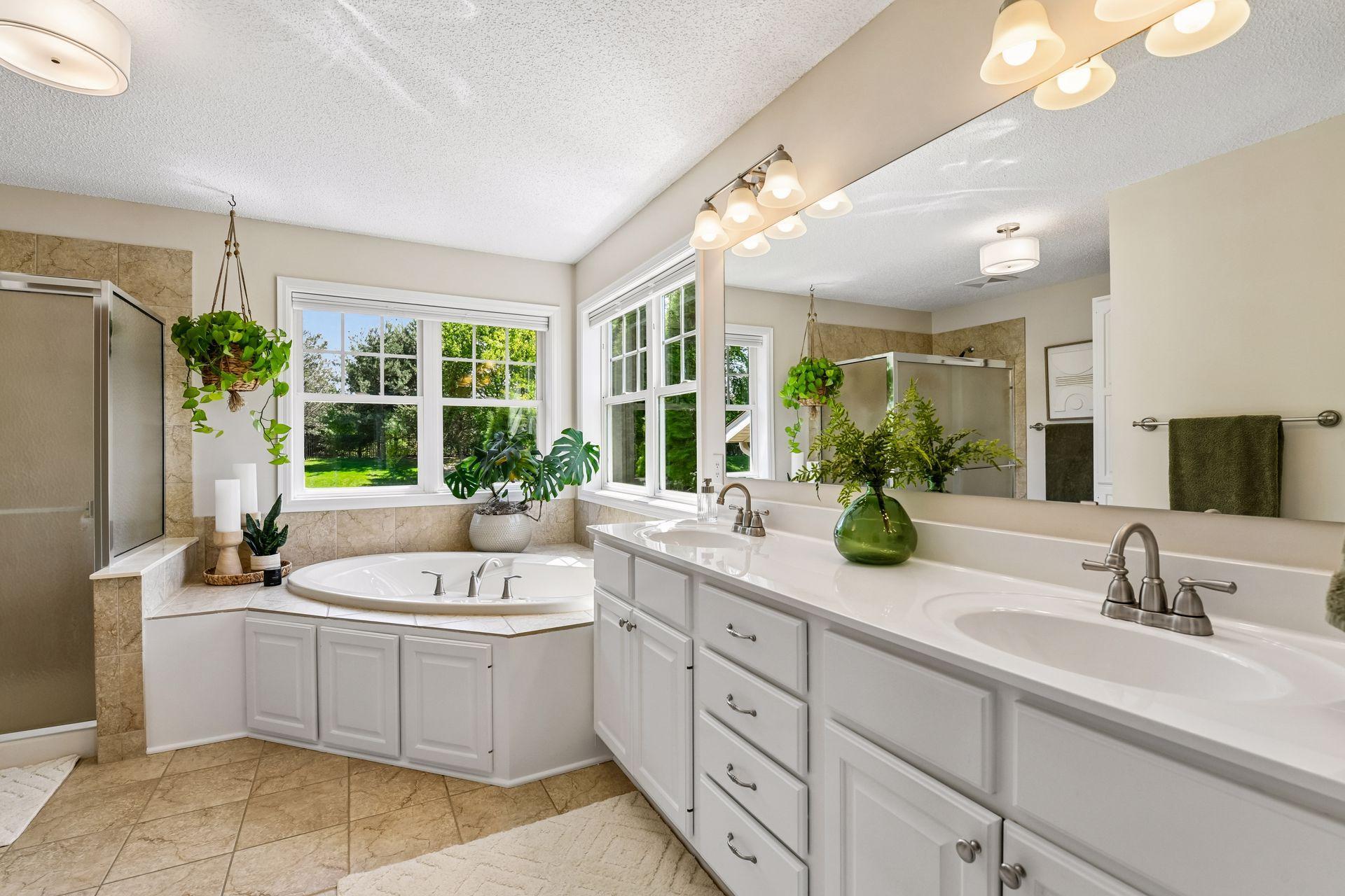 The Primary Bathroom features a comfort-height vanity with two sinks, a jetted bathtub and tiled shower. A walk-in closet completes the suite.