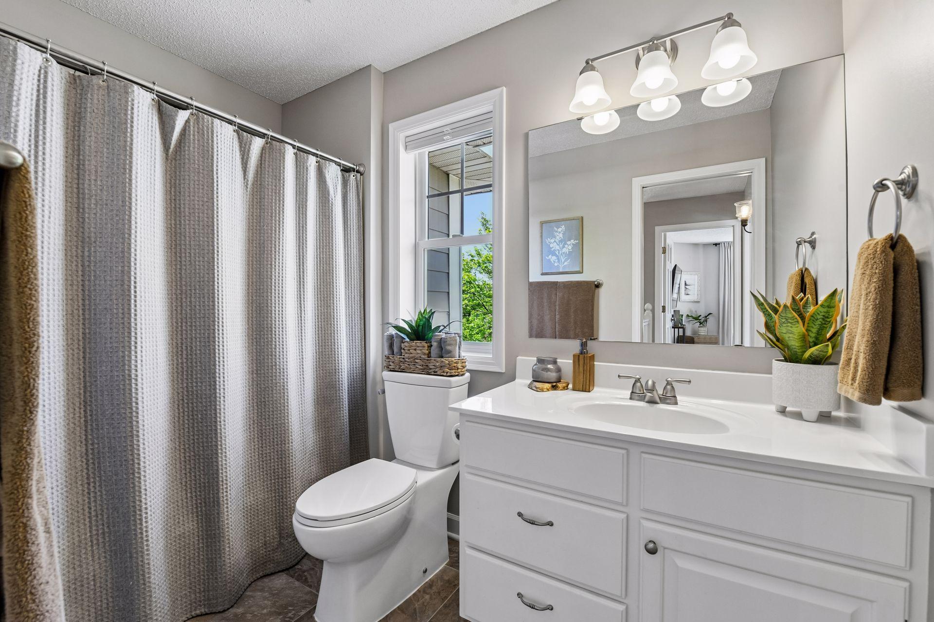 The full bathroom offers tiled flooring and enameled vanity.