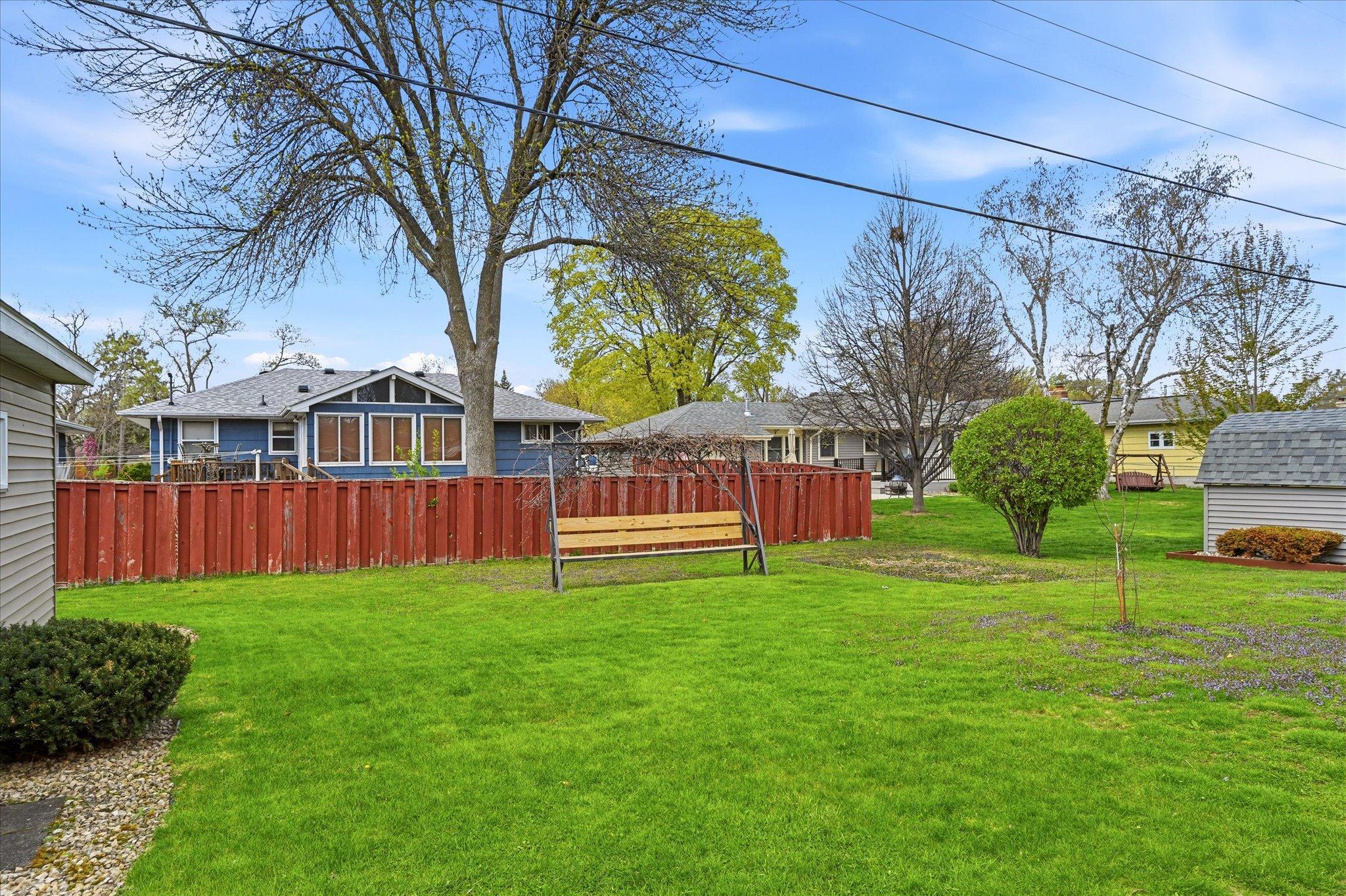 Flat partially fenced yard. Seated bench included.