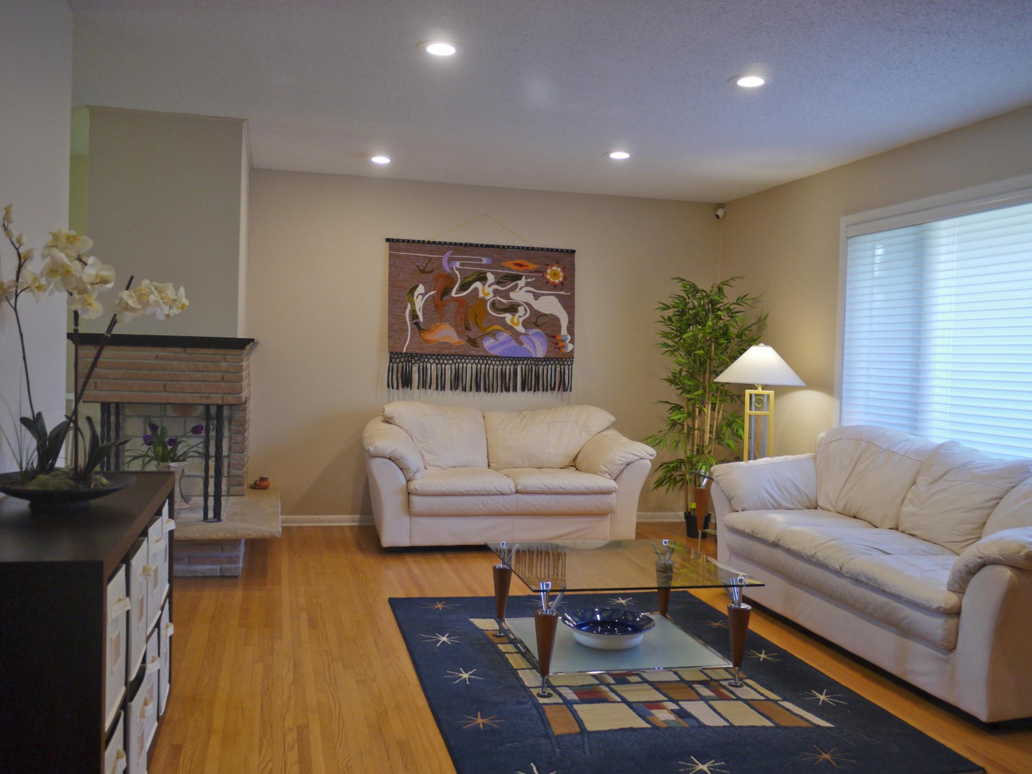 3 Main floor living room with 3 sided fireplace, solid oak flooring and North facing picture window.jpg
