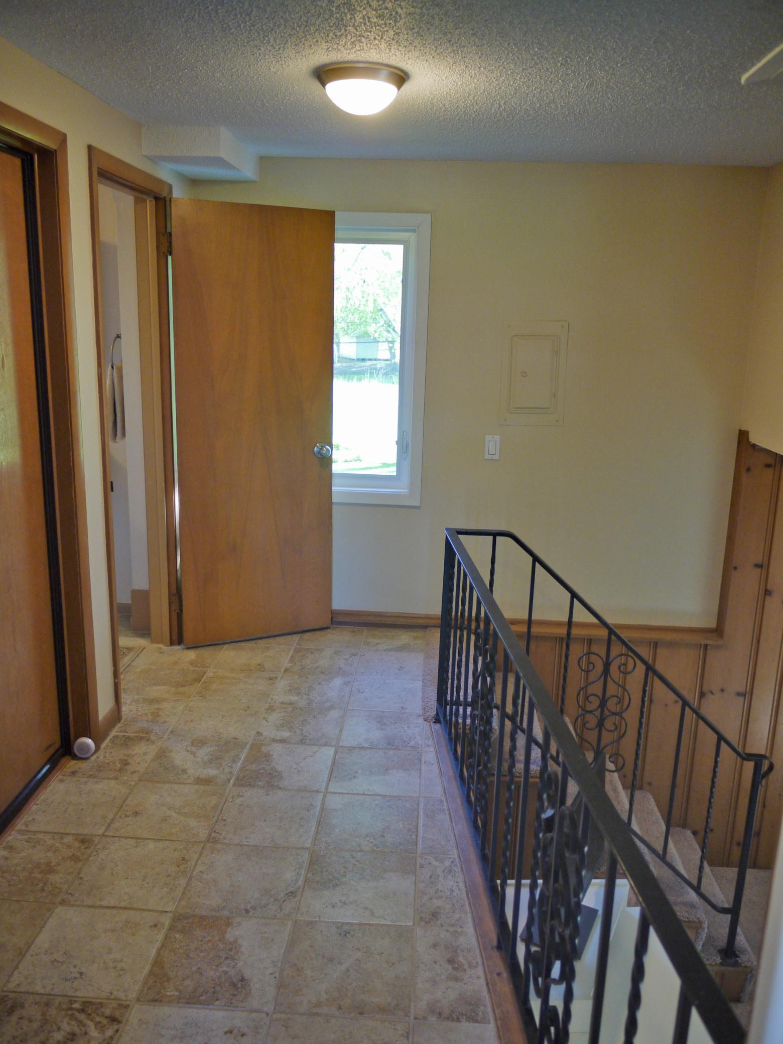 Hallway off foyer leading to lower level family room, guest bath and garage access.jpg