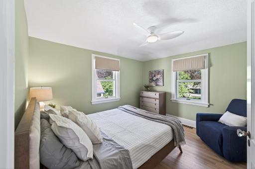 Bedroom 1 on upper level, freshly painted with custom window coverings and modern ceiling fan