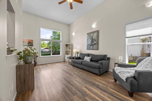 Natural light fills the living room through expansive windows across the open main level.
