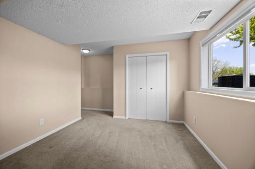 Lookout windows frame bright front-yard views from this lower-level fourth bedroom.