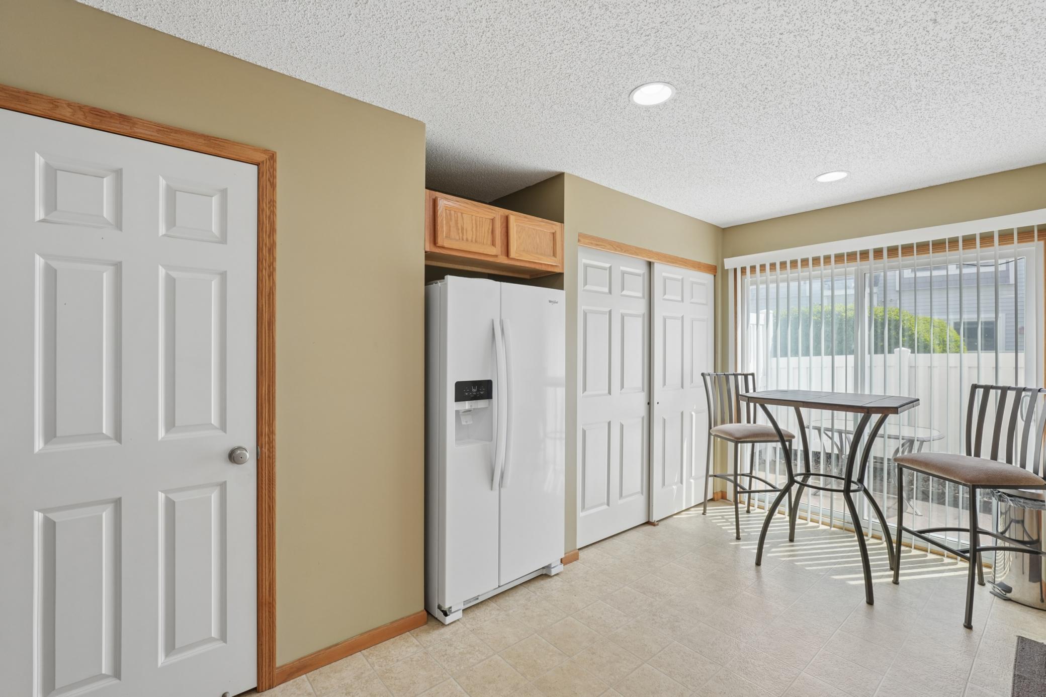 A view of the utility closet, new fridge and door to the main floor half bath.