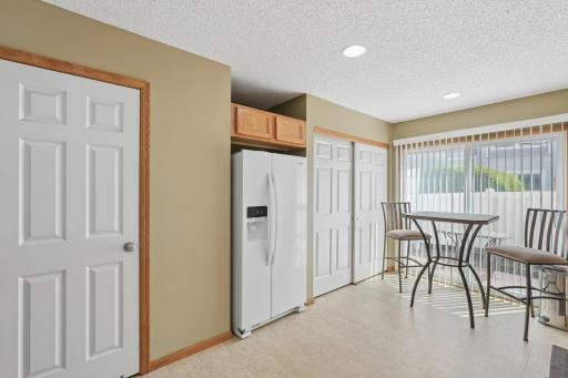 A view of the utility closet, new fridge and door to the main floor half bath.