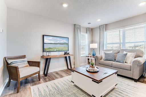 The main living space is open and full of light with an abundance of windows. (Model photo, colors may vary)