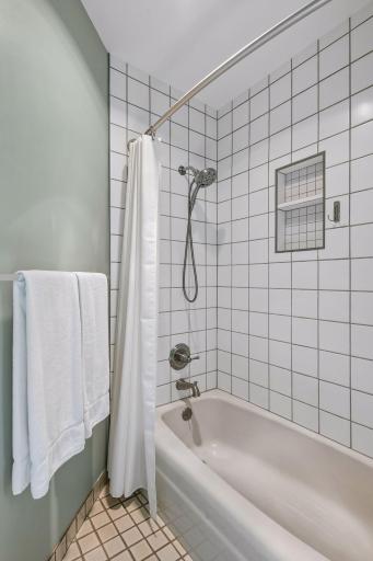 3/4 bath updated with white square tile and shampoo shelf