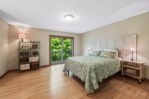 Primary bedroom with updated 3/4 bath and balcony overly the backyard