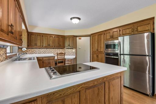 Quaint dark oak cabinets in large eat-in kitchen