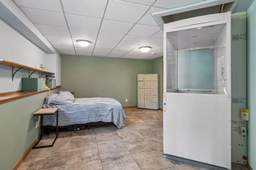 Lower-level bedroom with lift / elevator going up to main level living space