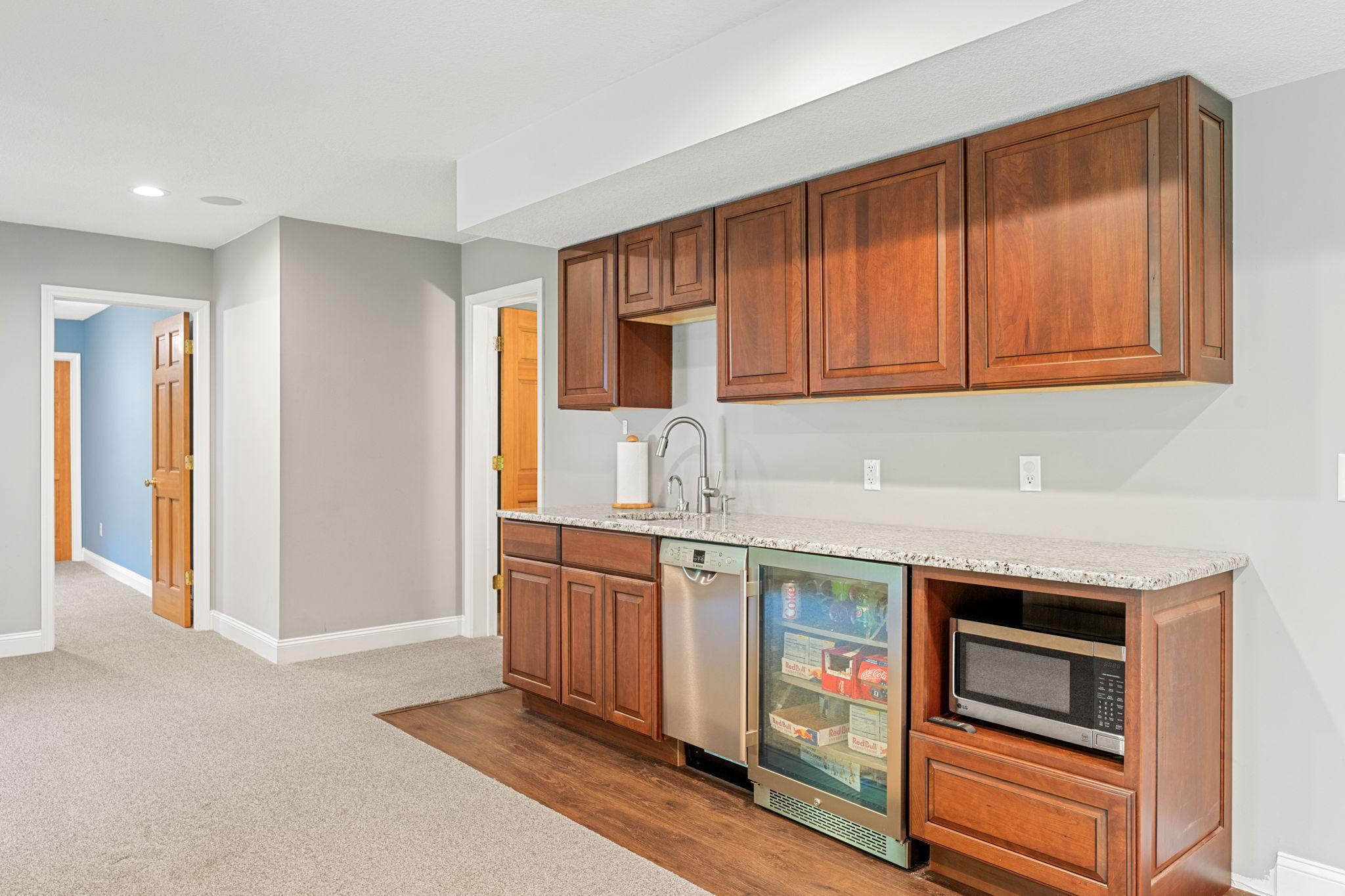 Convenient wet bar with dishwasher, mini-fridge & microwave.