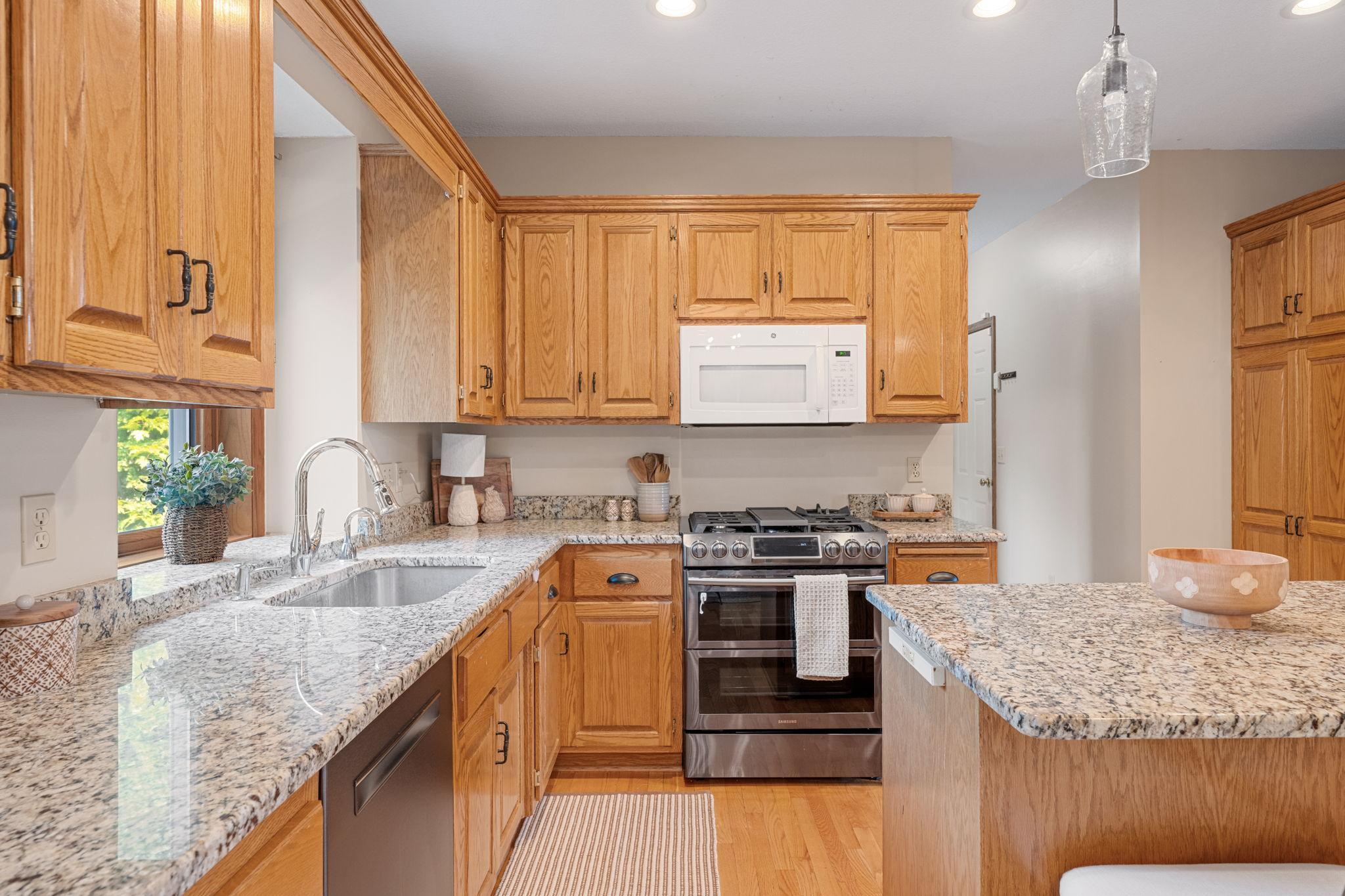 Ample cabinetry, granite countertops, stainless appliances and a center island make this a dream kitchen.