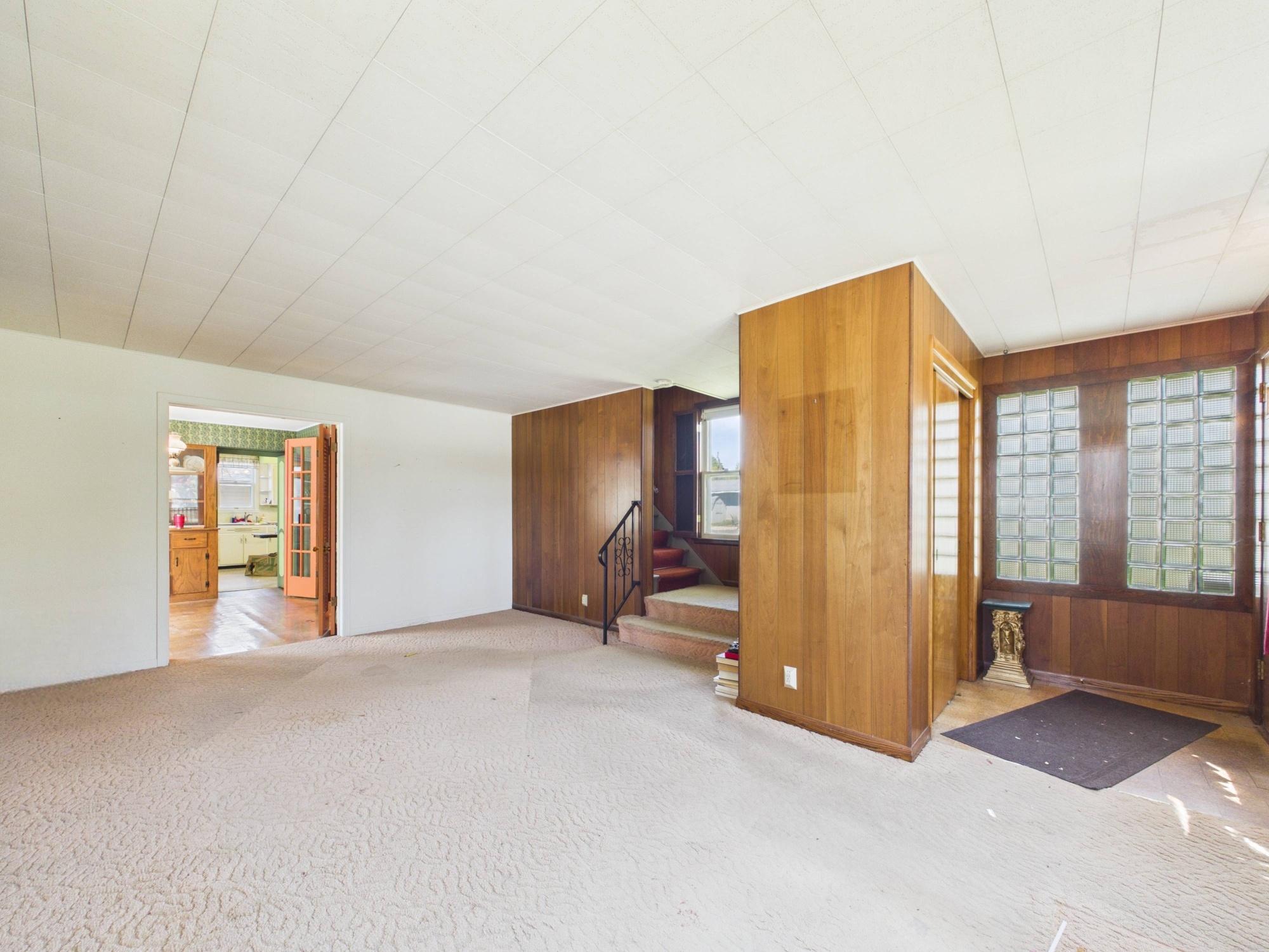 Spacious living room with tall ceilings and original character.