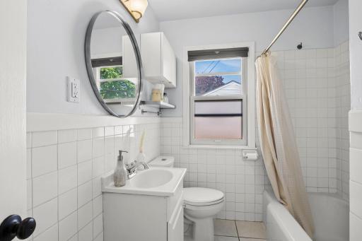 A full bathroom with tile surround extending through the tub and shower.