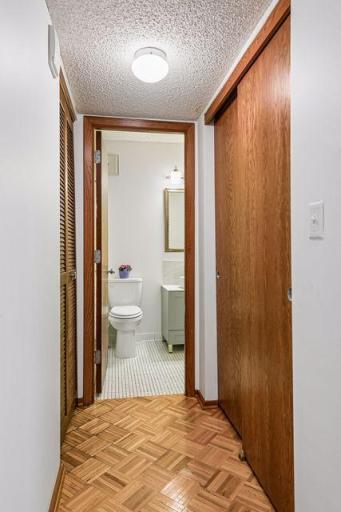 Hall to bathroom with large closet space on right and HVAC on the left