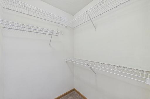 Generous walk in closet with built in shelving