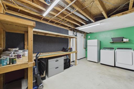 Huge laundry room with built-in shelving and the fridge stays.