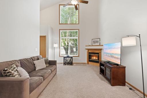 An impressive vaulted ceiling and stacked windows fill the spacious living room with natural light.