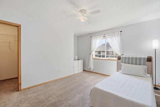 Plush carpet, walk in closet and a ceiling fan.