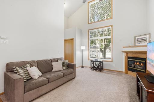 Warm wood flooring and trim add character, while the cozy fireplace creates an inviting focal point.