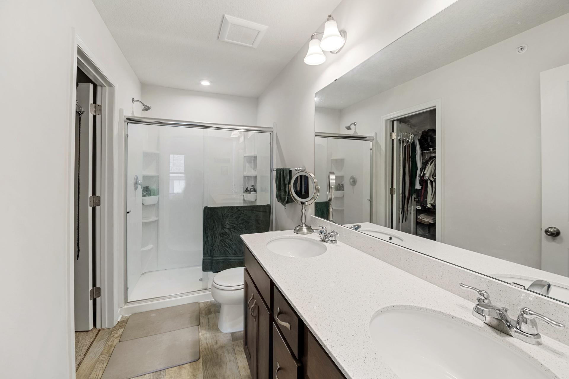 Primary bathroom with double sinks, large shower and walk-in closet.