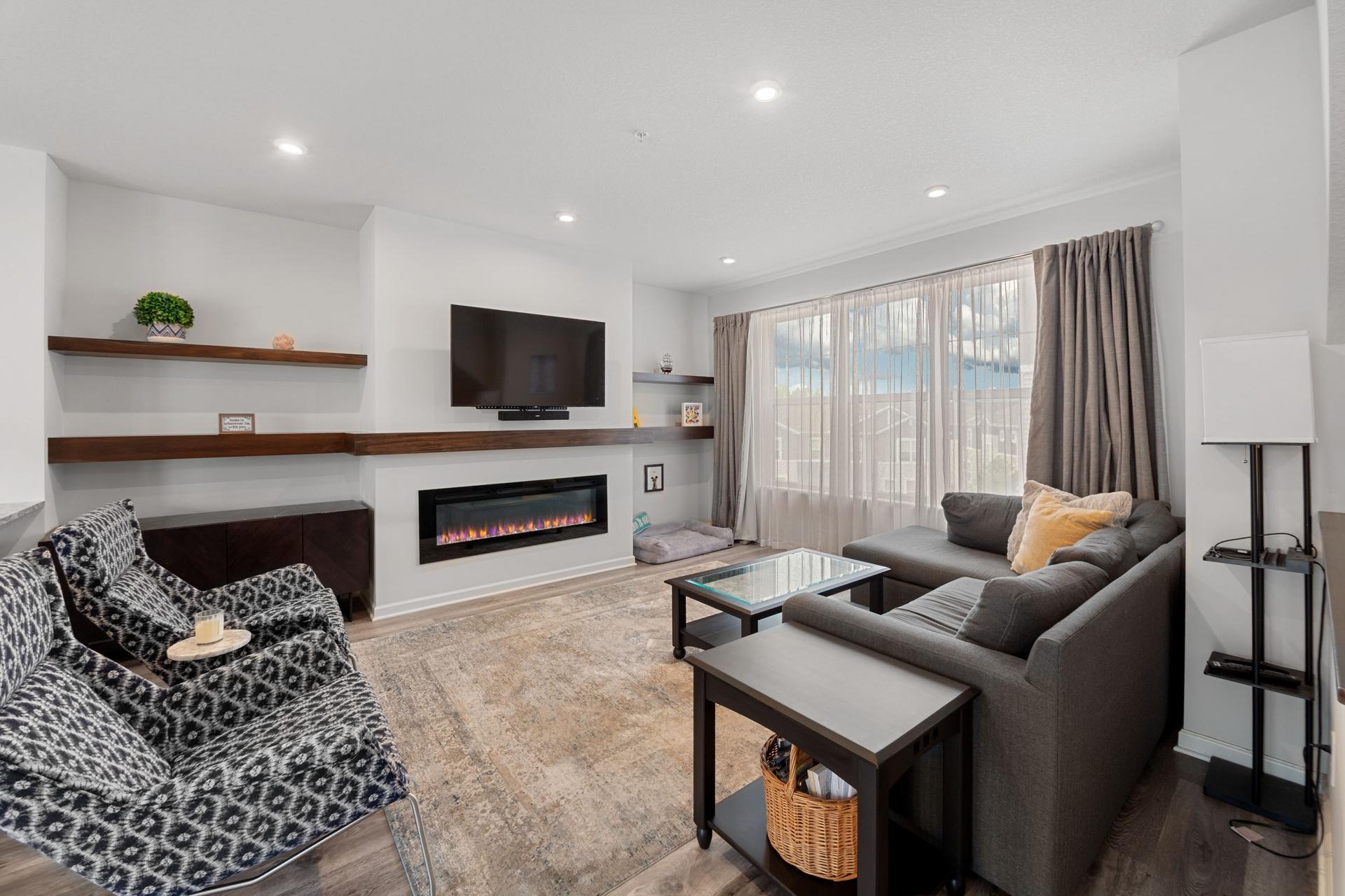 Living room has cozy fireplace and shelf system to display your favorite family photos and art.