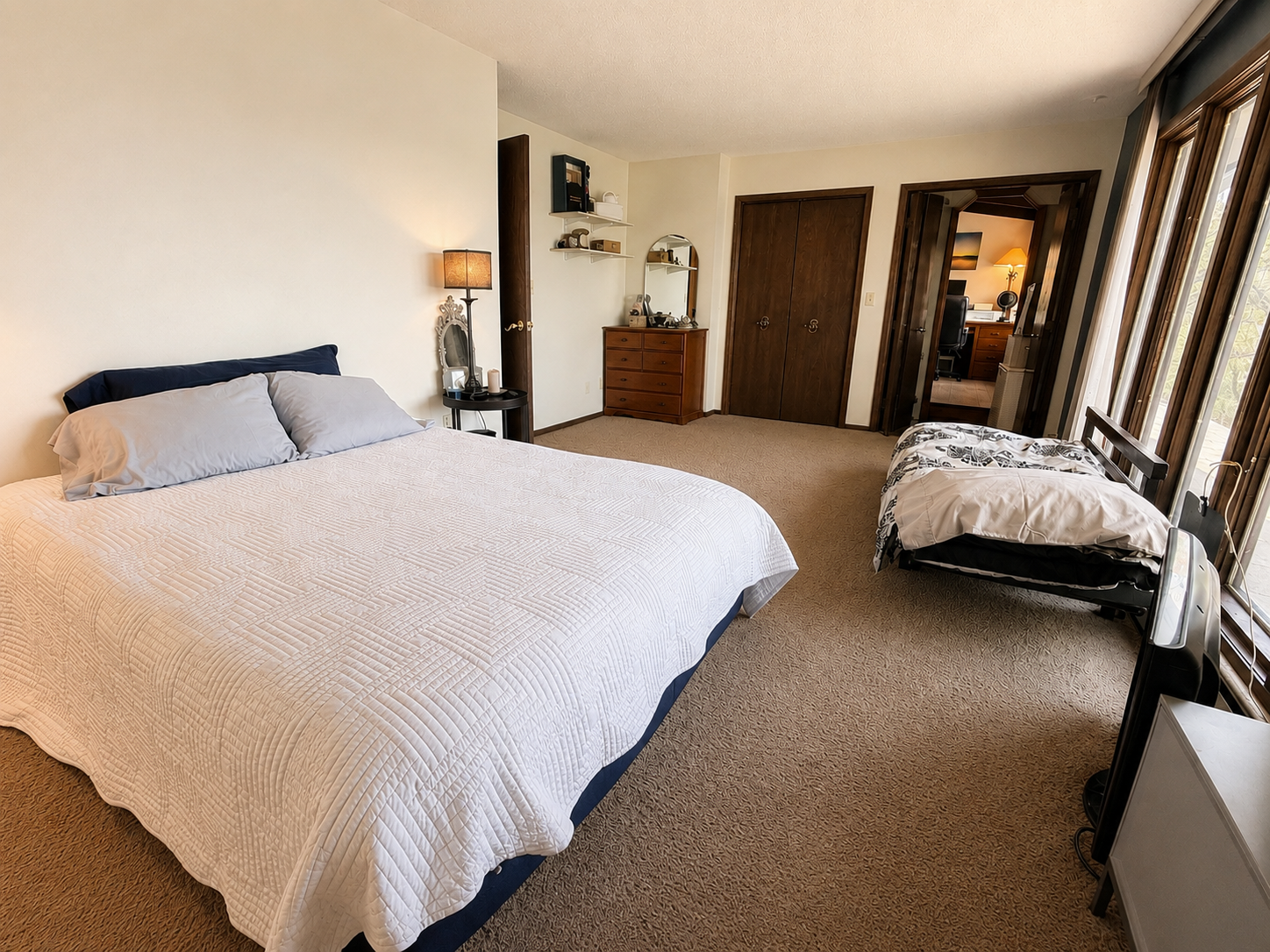 Main floor large bedroom with great lake views. This image is AI enhanced.