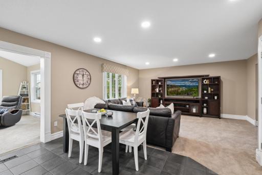 This inviting living room offers a seamless flow between the formal dining room, kitchen, and sunroom, creating a connected and functional space. The open layout is ideal for everyday living and easy entertaining, with clear sightlines throughout.