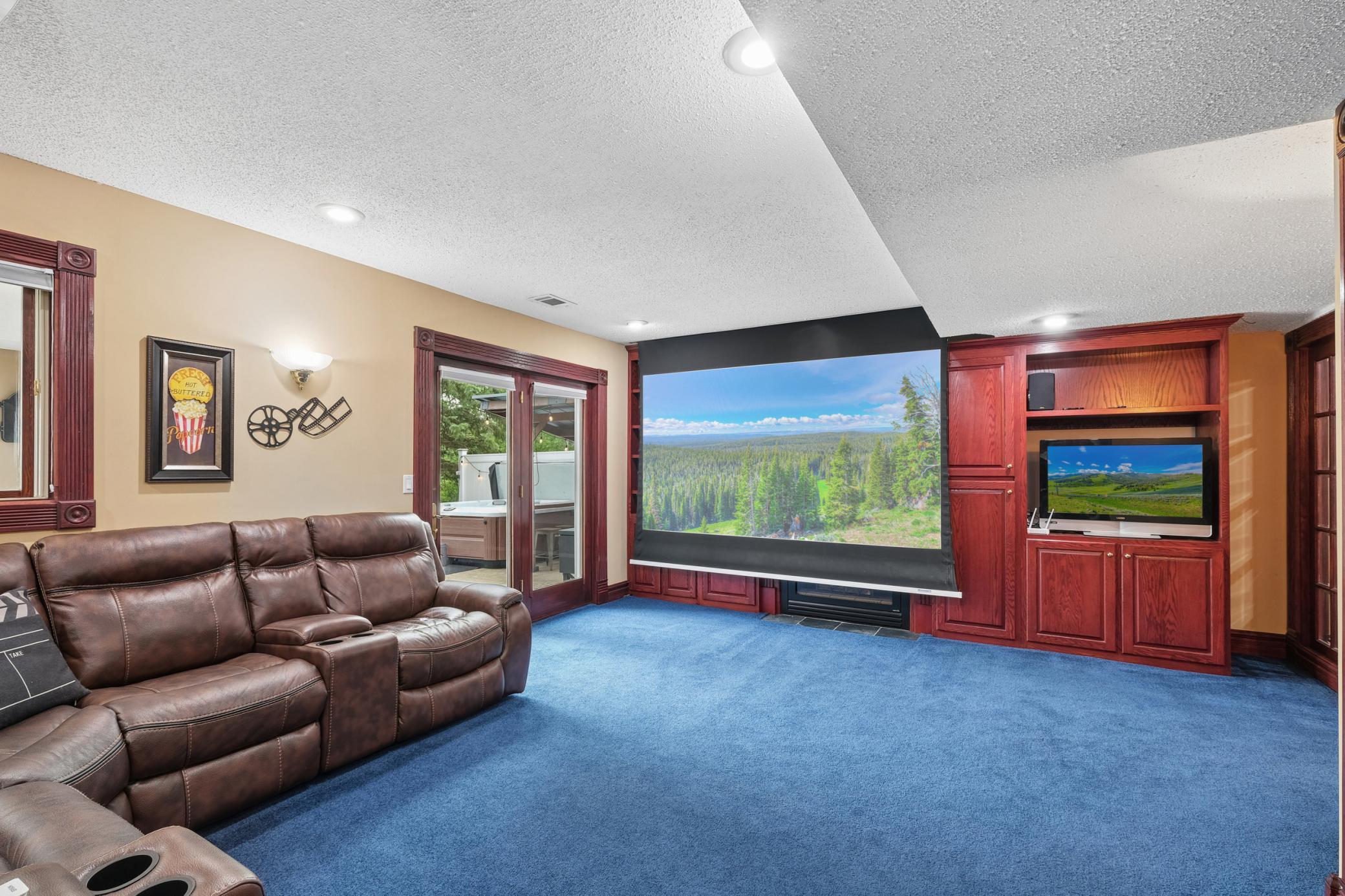 Enjoy movie nights and game days in the inviting family room featuring a gas fireplace and built-in projector, plus a spacious rec room perfect for gatherings, hobbies, or play space.