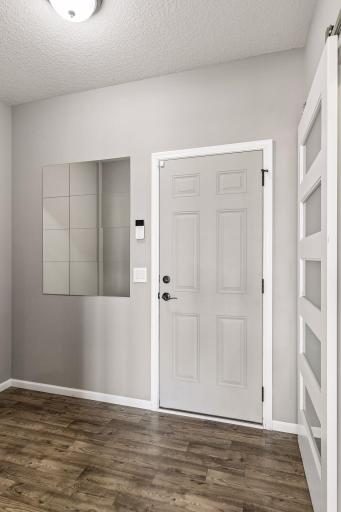 Mudroom with pass-through closet to front door and garage access