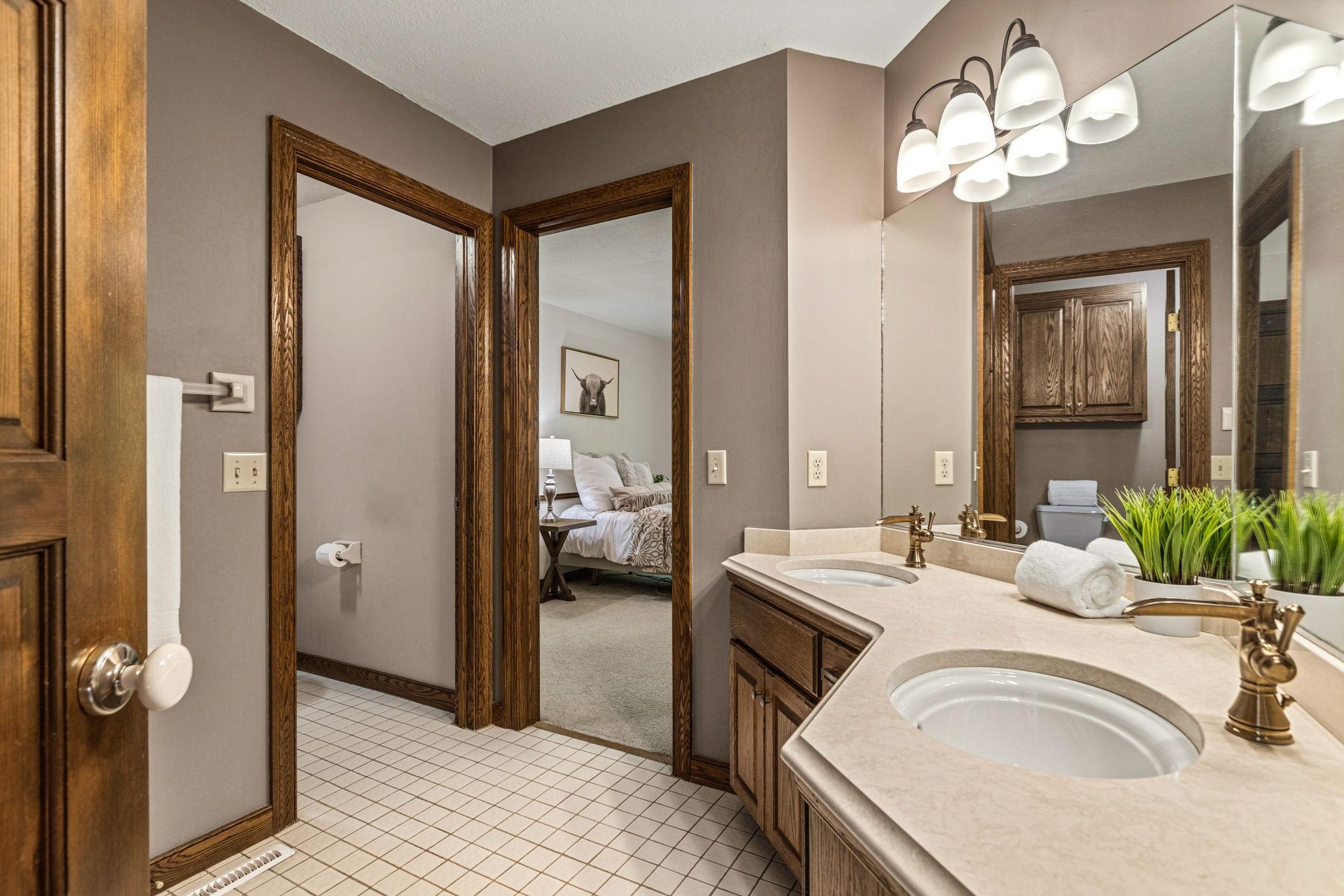 Jack n Jill bath on upper level with double sinks, tile flooring and quartz counters.