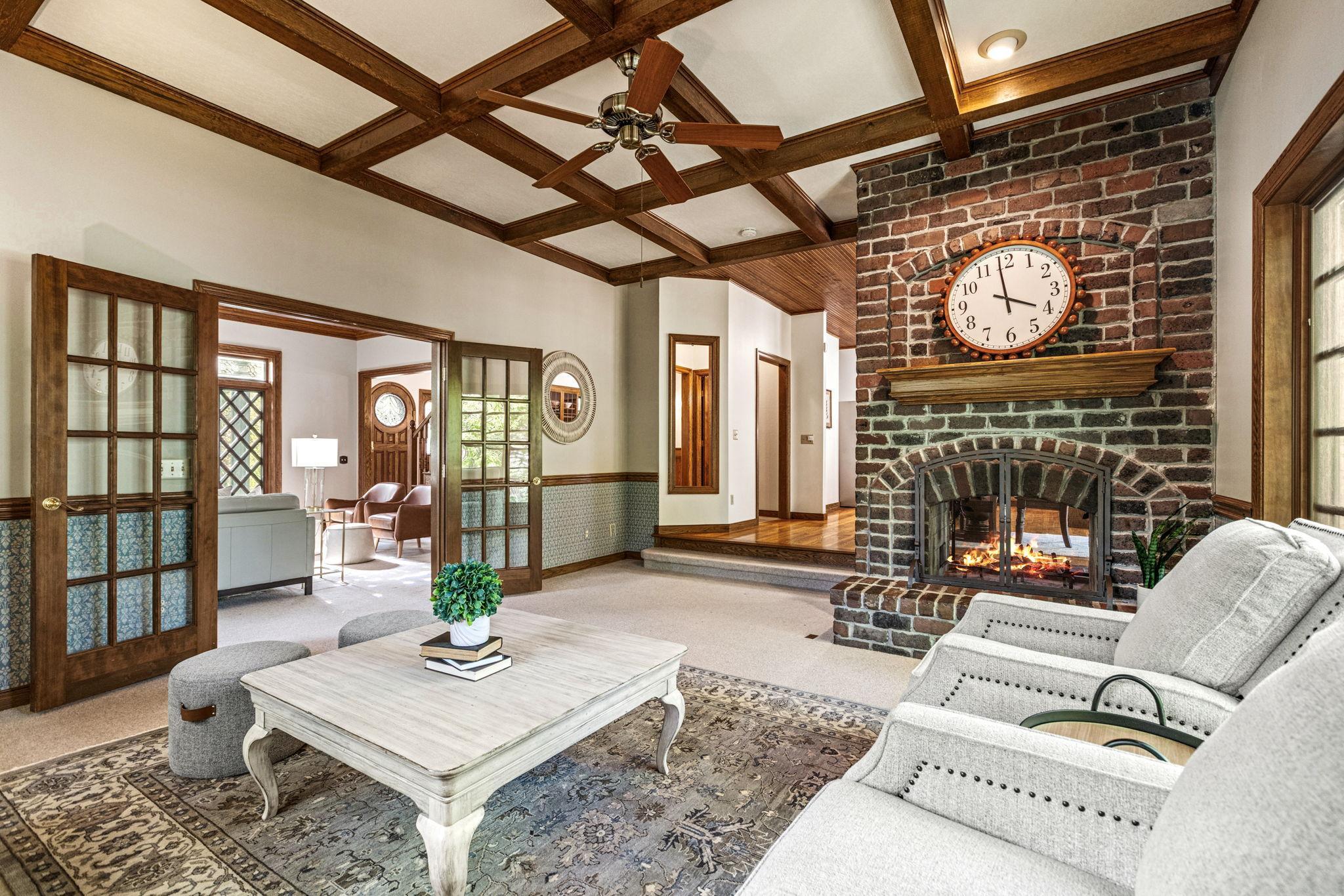Warm and inviting main floor family room featuring a dramatic floor-to-ceiling brick fireplace and rich architectural character throughout.