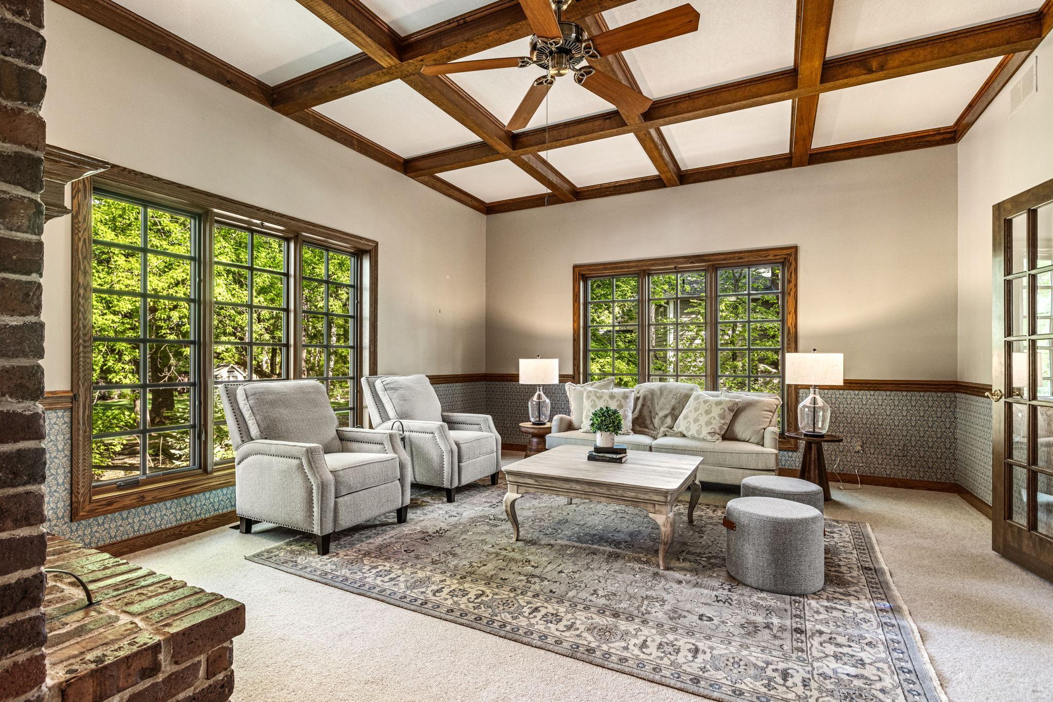 Spacious main floor family room with oversized windows, picturesque views and a stunning coffered ceiling that adds warmth and timeless character.