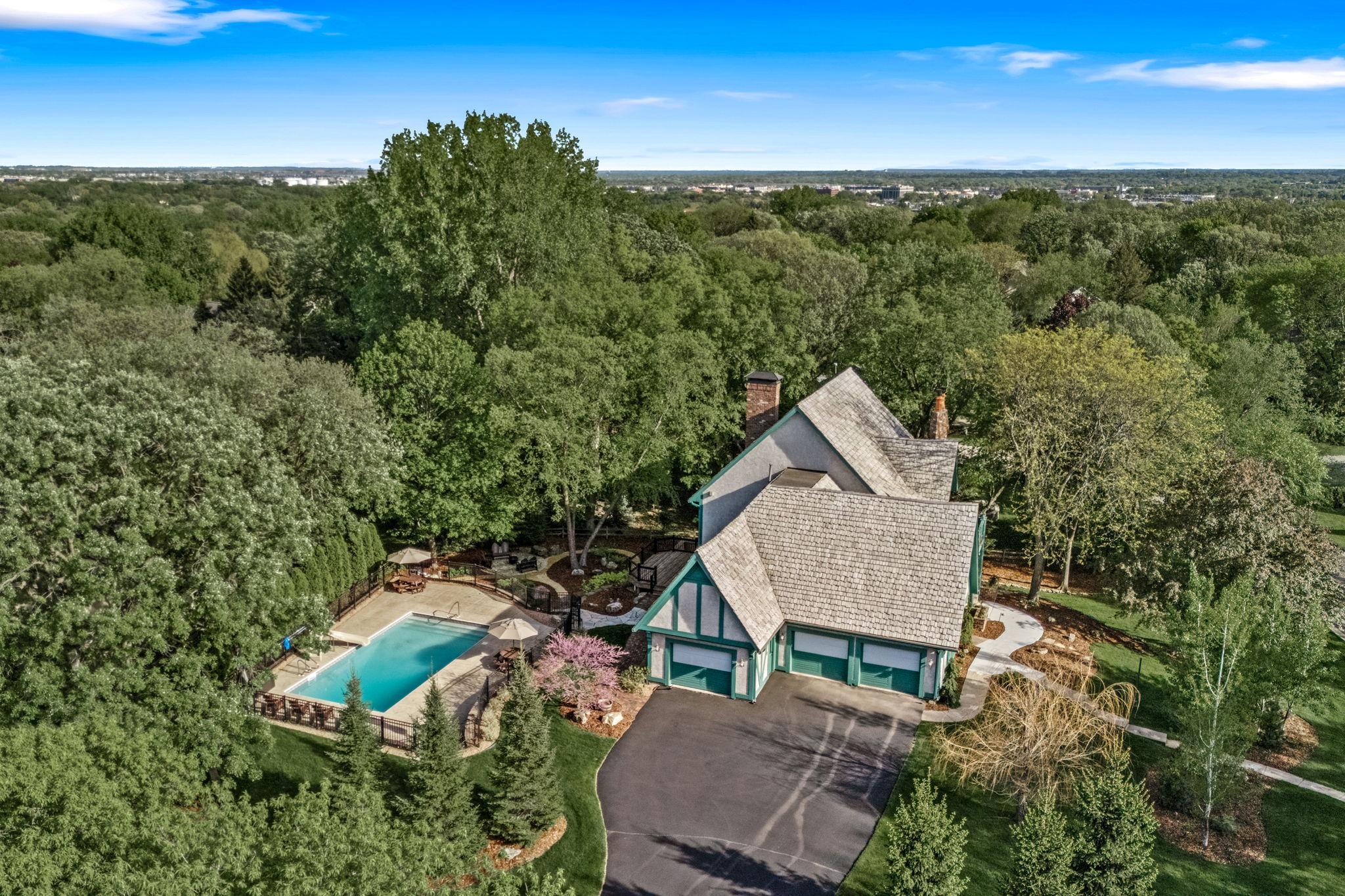 Spectacular aerial view showcasing this one-of-a-kind estate nestled among mature trees with exceptional privacy, extensive professional landscaping and resort-style outdoor living.