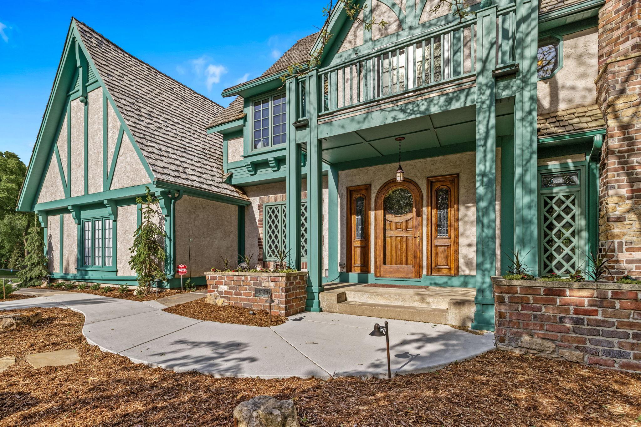 English Country Manor with striking Tudor-inspired architecture, dramatic entry and timeless curb appeal. A truly unforgettable first impression.