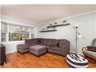 Living room has a great view of green space. Durable engineered flooring for an easy-to-clean space.