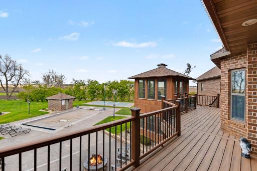 Composite deck overlooking backyard stamped concrete patio with inground swimming pool & basketball court/pickleball court