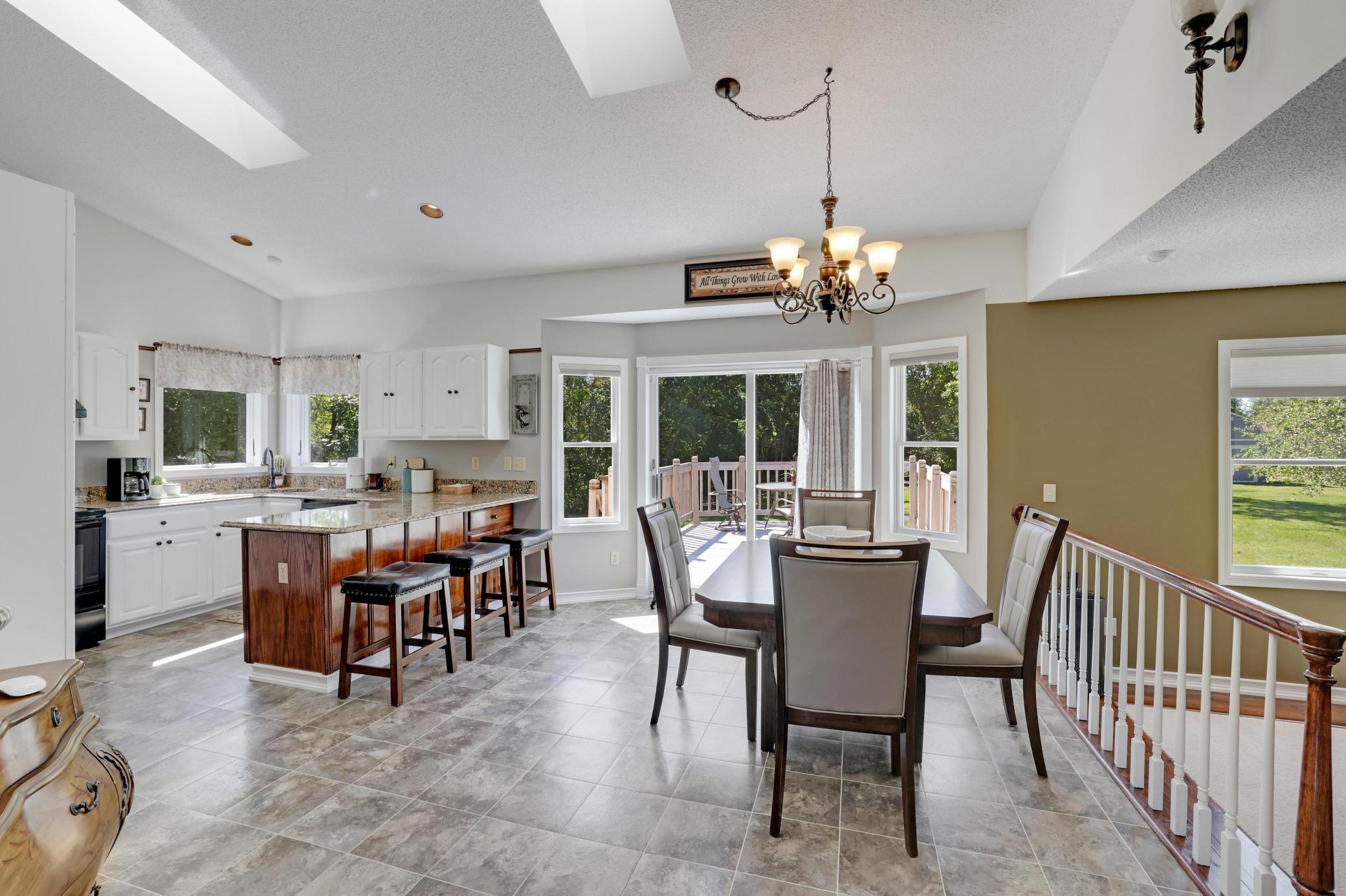 Spacious kitchen/kitchenette overlooking the large backyard lined with mature trees.