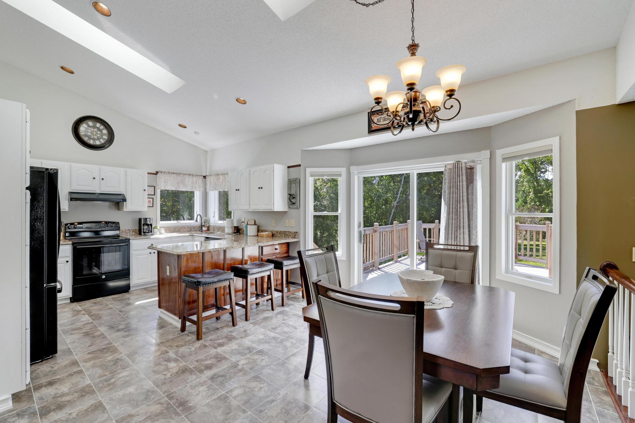 Spacious kitchen/kitchenette overlooking the large backyard lined with mature trees.