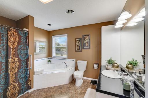 Full walk-thru primary bathroom w/ large soaking tub and shower.