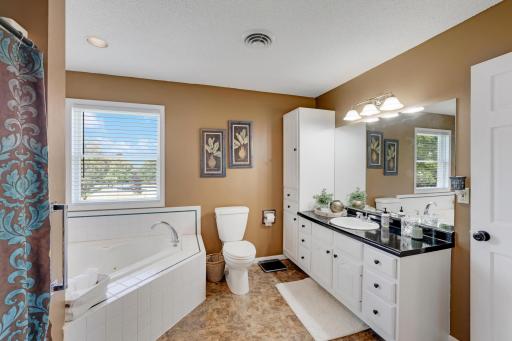 Full walk-thru primary bathroom w/ large soaking tub and shower.